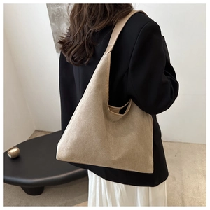 Detailed view of beige suede tote bag styled with a professional minimalist office outfit