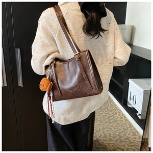 Vista dettagliata della borsa tote vintage marrone in pelle cerata con ciondolo a cucciolo