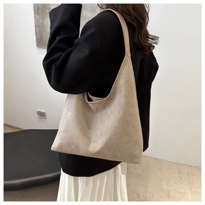 Detailed view of beige suede tote bag showing soft texture and reinforced leather straps