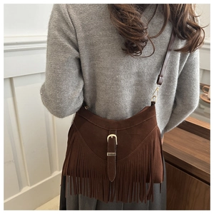 Detail of bohemian dark brown fringe tote bag with belt buckle and faux suede texture