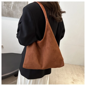 Détail d'un grand cabas en daim marron avec une texture mate de qualité et coutures propres