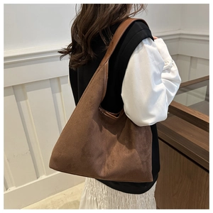 Detailed view of brown faux suede tote bag showing soft matte texture and large hobo shape