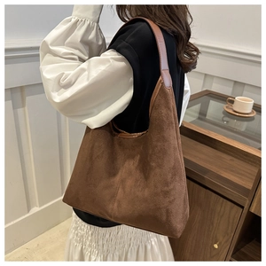 Détail du sac hobo en daim marron foncé avec bandoulière en cuir et grand intérieur