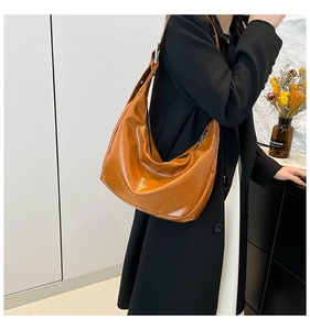 Detail of caramel brown hobo bag showing soft texture and wide shoulder strap