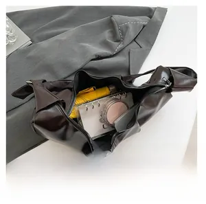 Interior view of brown hobo bag showing large capacity for umbrella, phone, and notebook