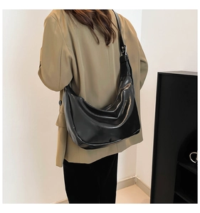 Model wearing a large black hobo bag with a soft leather finish and adjustable shoulder strap