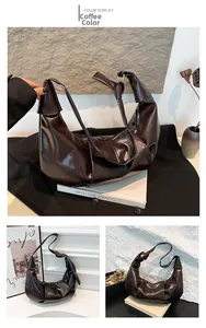 Macro detail of glossy coffee brown pleated shoulder bag with knotted handle and metal ring
