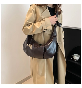 Dark coffee crescent shoulder bag with pleated leather and bow knot detail on model