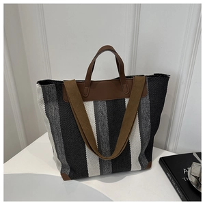 Detail of striped canvas tote bag showing thick fabric texture and leather handles