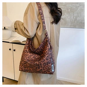 Detail of leopard print hobo bag showing large metal eyelets on the wide shoulder strap