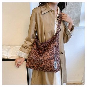 Detail of adjustable wide strap and buckle on leopard print suede tote bag