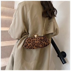 Dettaglio della borsa leopardata con chiusura a perla e tracolla a catena d'oro