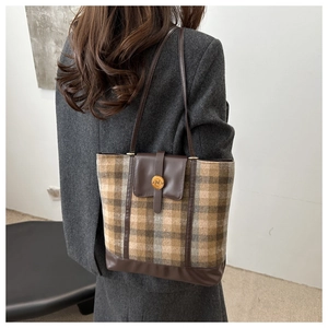 Detail view of the retro plaid tote bag showing its textured wool fabric and metal N buckle