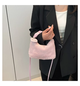 Detail of pink faux fur handbag featuring gathered satin handles and a fashion brand tag