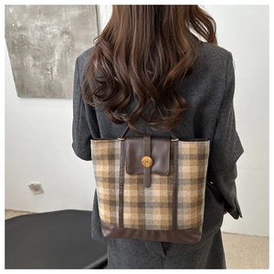 Detail of the large checkered tote bag showing leather patchwork and round metal button