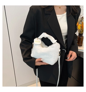 Detailed macro view of white plush faux fur handbag with golden metal buckles and leather handle