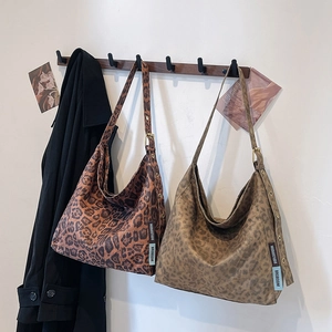 Large leopard print suede tote bag in light and dark patterns on a wooden wall hook