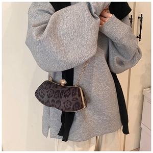 Détail du sac léopard avec bandoulière chaîne dorée et boucle élégante ornée de perles