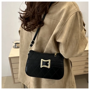 Détail d'un sac bandoulière matelassé noir avec fermoir doré et cuir brillant luxueux