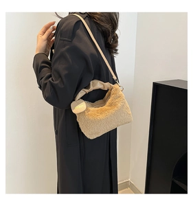 Close-up of beige plush faux fur bag featuring cloud-shaped handle and long strap