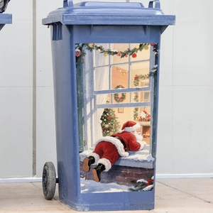 Macro shot of Santa Claus peering through snow window decal on a blue outdoor waste bin