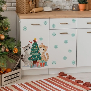 Close-up of Christmas wall stickers featuring cats hugging a tree and green snowflakes