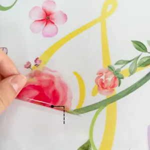 Detail showing adhesive floral wall sticker being peeled off white surface