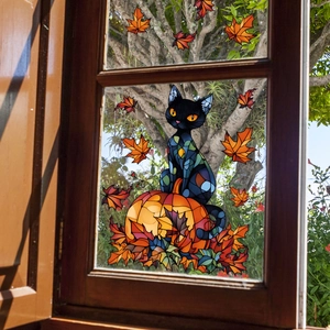 Detail of Halloween window sticker featuring a black cat on a pumpkin with maple leaves