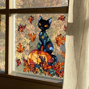 Stained glass style window sticker featuring a black cat, pumpkin, and autumn maple leaves