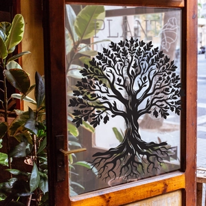 Adesivo elettrostatico nero a silhouette di albero su porta in vetro con vista