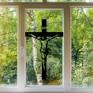 Dettaglio dell'adesivo per finestre a forma di crocifisso nero su vetro con foresta