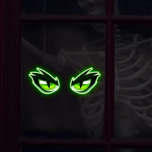 Dettaglio di adesivi murali con occhi di mostro verdi luminosi su legno per Halloween