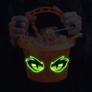 Secchiello per caramelle a zucca di Halloween con occhi verdi luminosi e dolci vari