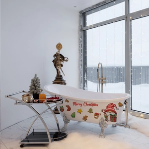 Close-up of Merry Christmas graphic and Santa patterns on a white clawfoot bathtub