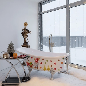 Close-up of Christmas gnome decals on a vintage white bathtub with a snowy window background