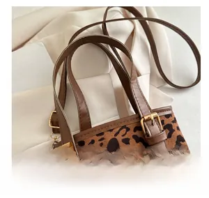 Detail of leopard print bucket bag with brown leather strap and gold metal buckle hardware