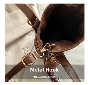 Macro shot of gold metal hook and buckle on brown leopard print bucket bag detail