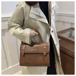 Détail du sac à main en cuir PU marron avec boucles dorées et texte de mode gravé