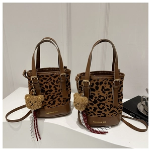 Detail of leopard print bucket bags with leather trim and brown plush bear charm