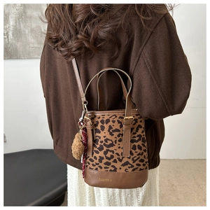 Macro detail of leopard print bucket bag with plush charm and fashion logo print
