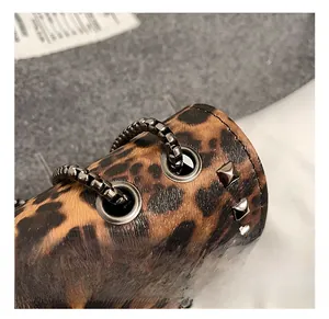 Detail of leopard print leather handbag with metal chain and square stud accents