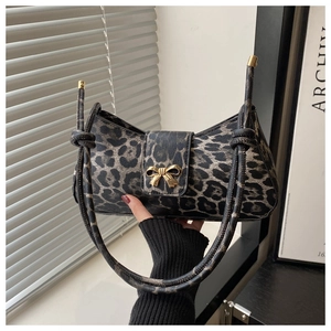 Detail der Schultertasche mit Leopardenmuster, goldener Schleife und Knotengurt