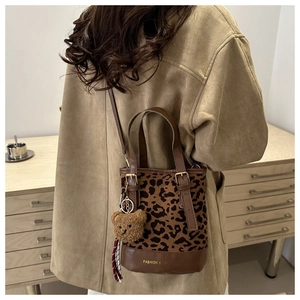 Detail of leopard print bucket bag with plush bear charm and vintage brown base