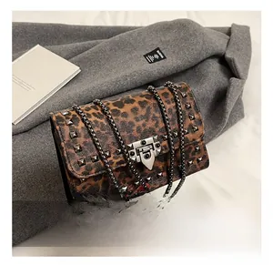 Macro shot of leopard print shoulder bag with metal studs and double chain straps