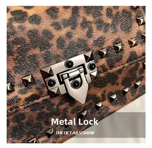 Detail of silver hardware lock and square studs on leopard print leather crossbody bag