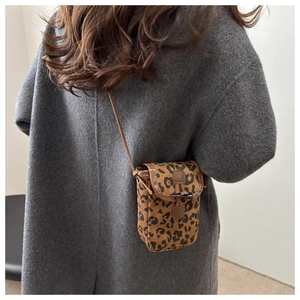 Macro detail of leopard print shoulder bag on grey wool coat with slim strap