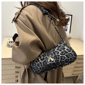 Detail of leopard print underarm bag with gold bow buckle on trench coat model
