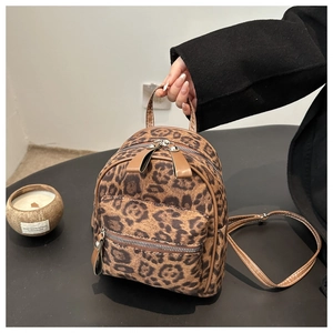 Gros plan du mini sac à dos à imprimé léopard avec tissu texturé et zips en métal