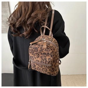 Détail du mini sac à dos léopard montrant la texture pelucheuse et les lanières en cuir