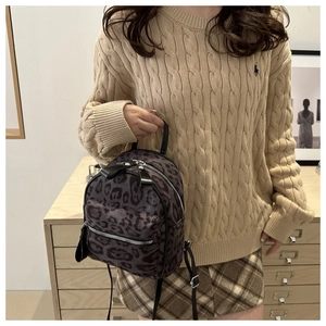 Détail du mini sac à dos à motif léopard avec texture douce et poche zippée